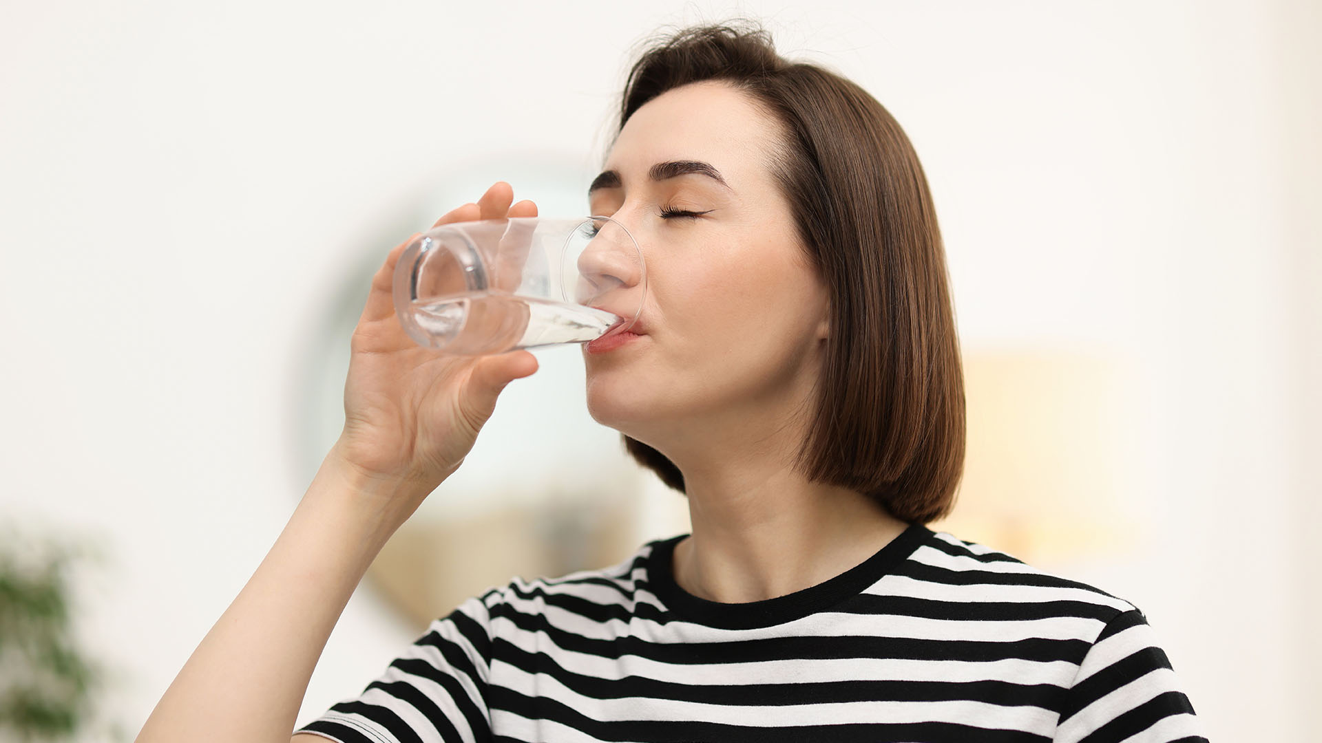 Frau trinkt ein Glas Wasser bei Mundtrockenheit