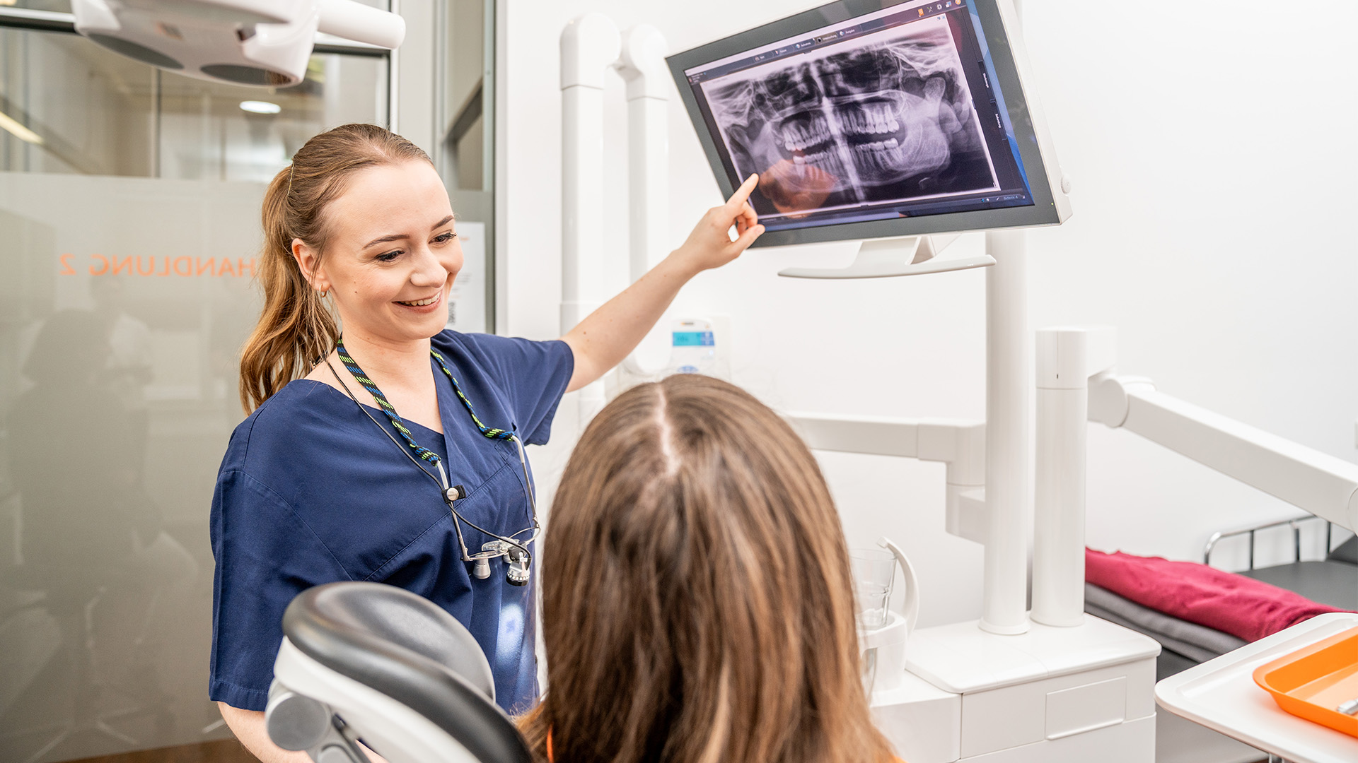 Zahnärztin der ZTK Zahngesundheit bespricht mit einer Patientin eine Röntgenaufnahme.