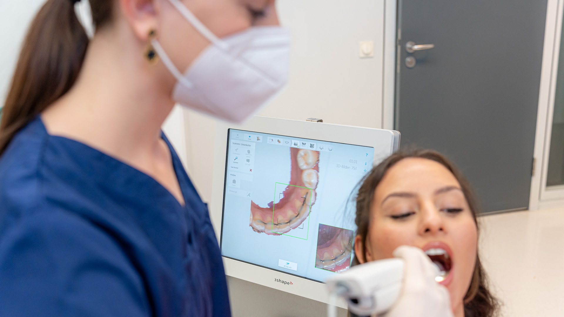 Behandlungsteam scannt die Zähne einer Patientin mit einem Intraoralscanner.